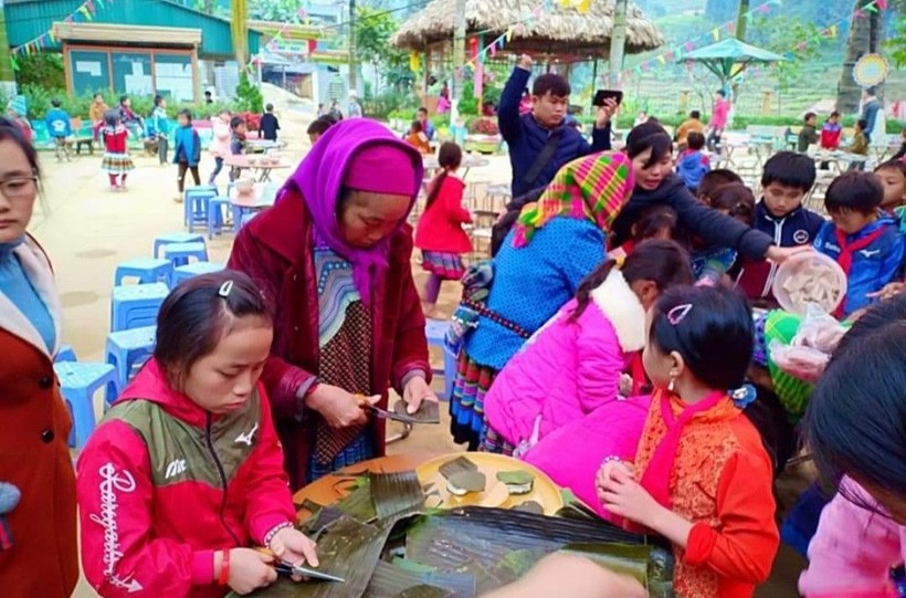Phụ huynh Trường Tiểu học số 1 xã Sín Chéng (Si Ma Cai, Lào Cai) tham gia làm bánh gây quỹ ủng hộ học sinh nghèo. Ảnh: NTCC